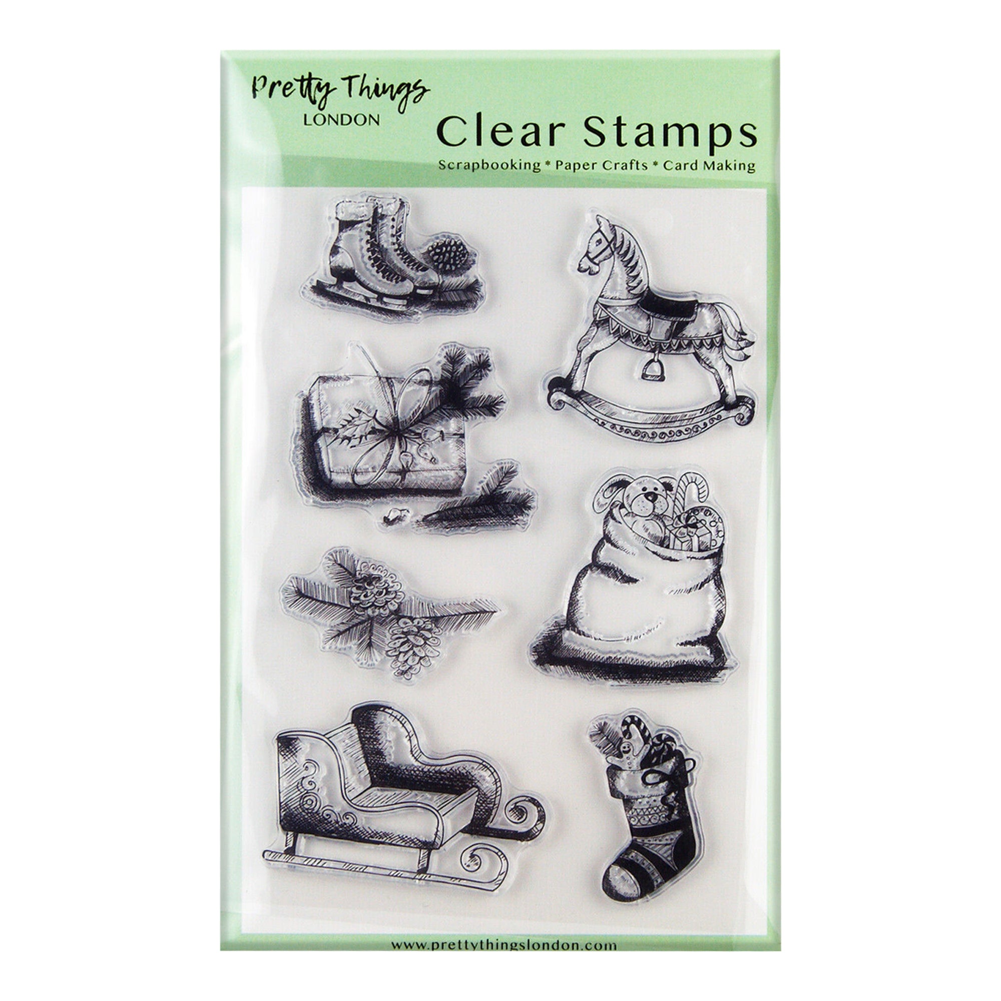 A set of clear stamps from Pretty Things London featuring various Christmas-themed designs. The stamps include a pair of ice skates, a rocking horse, a pine branch with cones, a wrapped gift, a bag of toys, a sleigh, and a Christmas stocking.