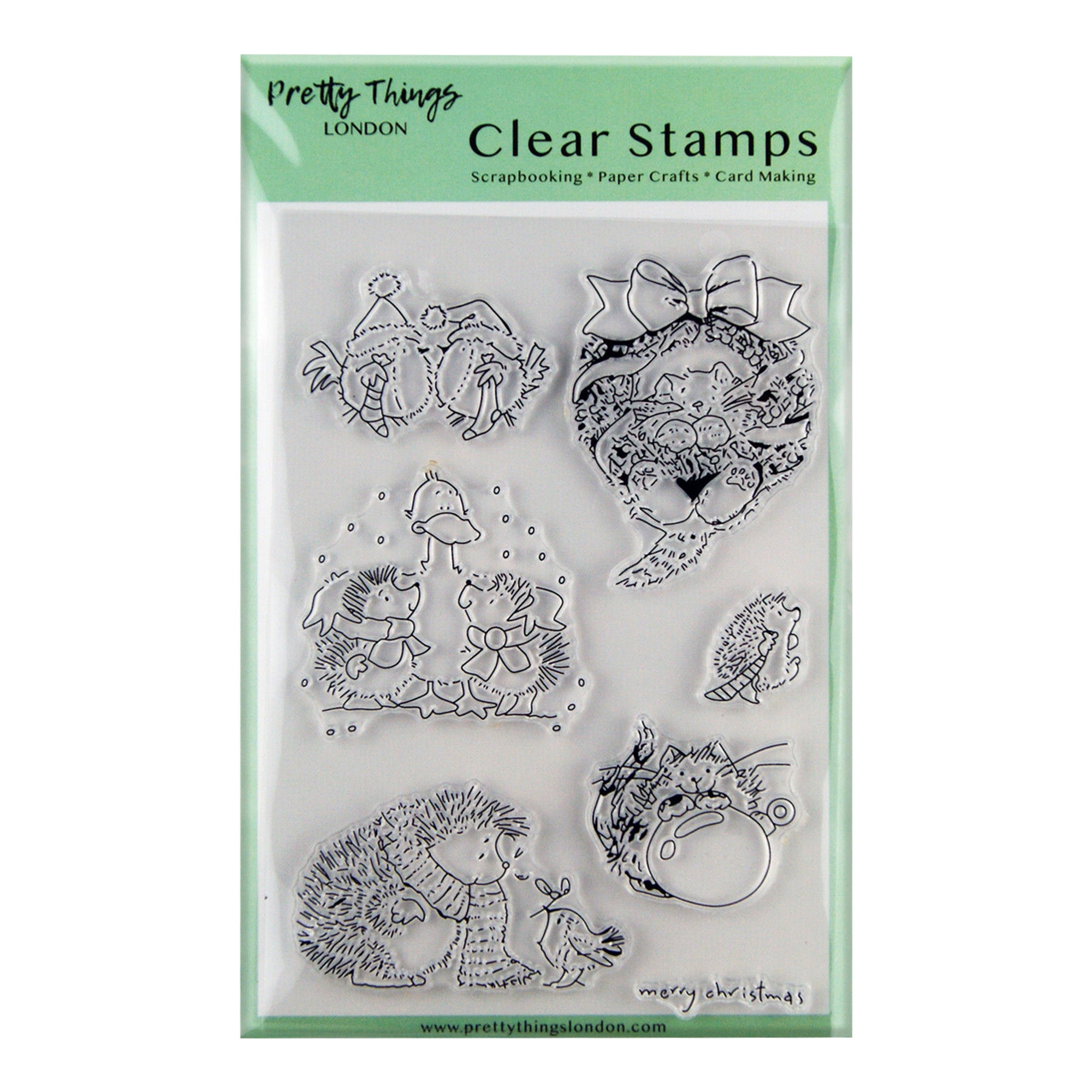 A set of six clear stamps from Pretty Things London, featuring winter animals in various festive scenes, including hedgehogs, ducks, and a cat with a Christmas bauble. The stamps are packaged in a clear plastic sheet with a green background.