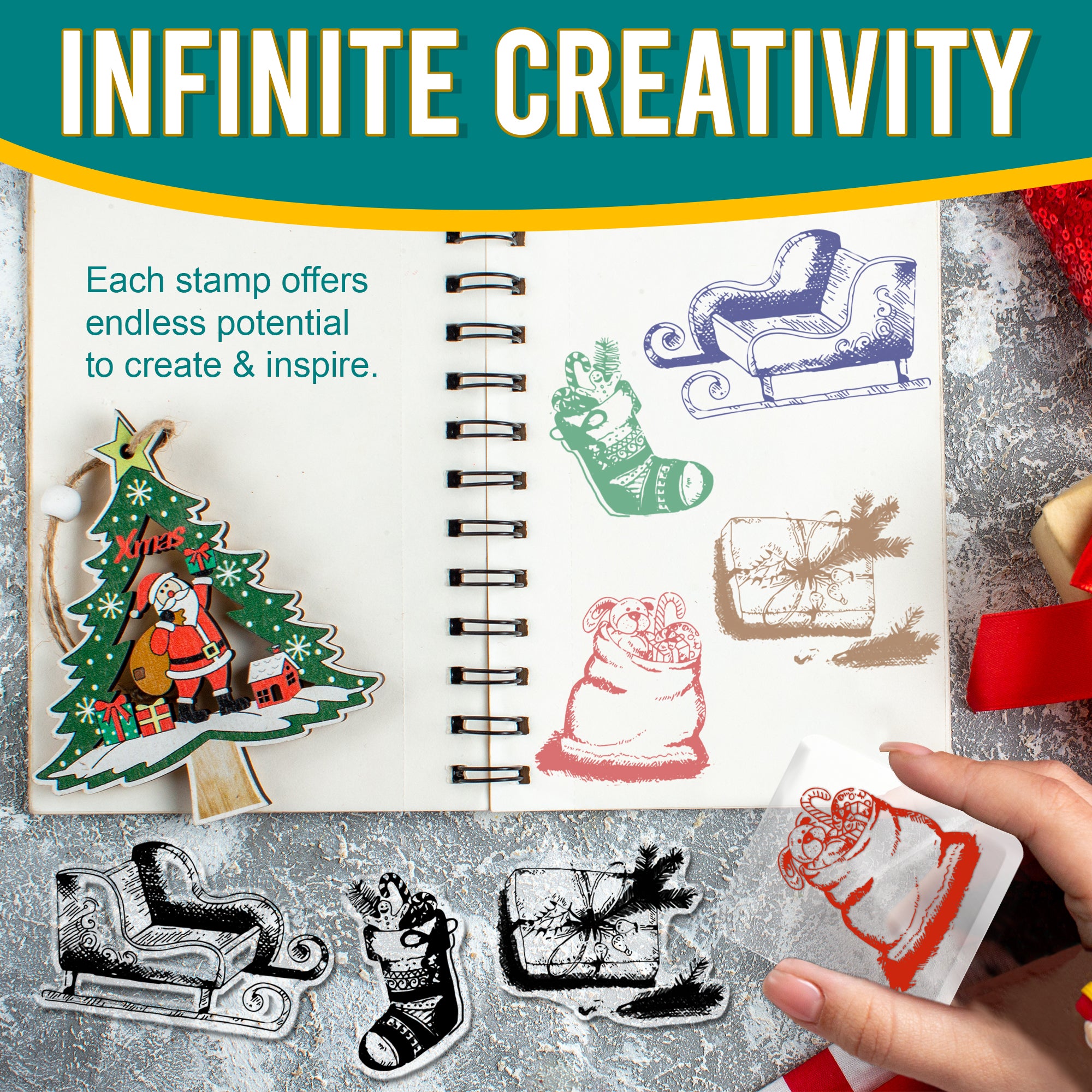 Notebook open to a page showcasing various stamped images, including a sleigh, Christmas stocking, gift, bag of toys, and pine branch. Each stamp is inked in different colours. A hand is seen using one of the stamps on the page, with a decorated Christmas tree ornament on the side.