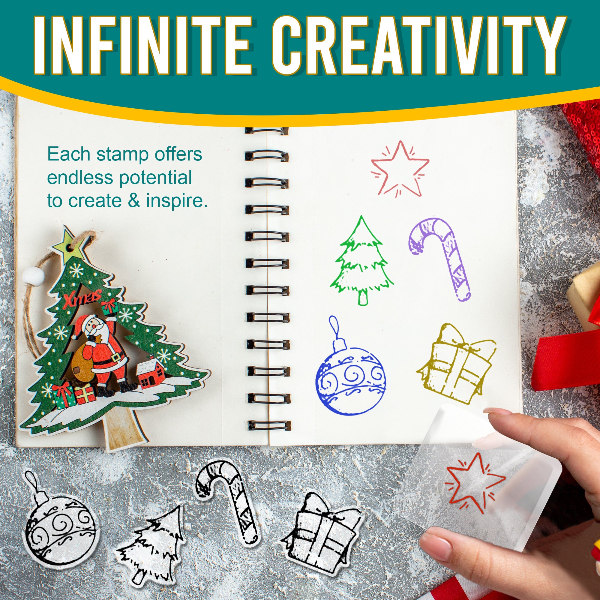 A notebook displaying creative uses of the clear stamps. Different stamps, such as a Christmas tree, a candy cane, and a gift box, are stamped in various colours. The background includes festive decorations, a handmade Christmas tree ornament with Santa, and a person holding an acrylic block with a star stamp. Text overlay reads: 'INFINITE CREATIVITY. Each stamp offers endless potential to create & inspire.'